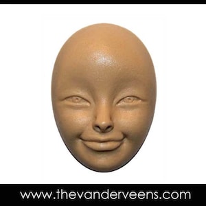 May include: A light brown ceramic sculpture of a face with a neutral expression. The face has a rounded shape and features a small nose, closed mouth, and large eyes.