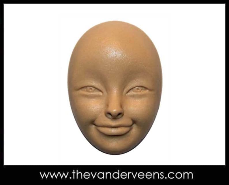 May include: A light brown ceramic sculpture of a face with a neutral expression. The face has a rounded shape and features a small nose, closed mouth, and large eyes.
