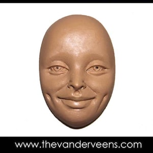 Puede incluir: Un primer plano de una escultura de arcilla marr&oacute;n de una cara con una expresi&oacute;n sonriente. La escultura tiene una superficie lisa y redondeada y presenta ojos, nariz y boca realistas.