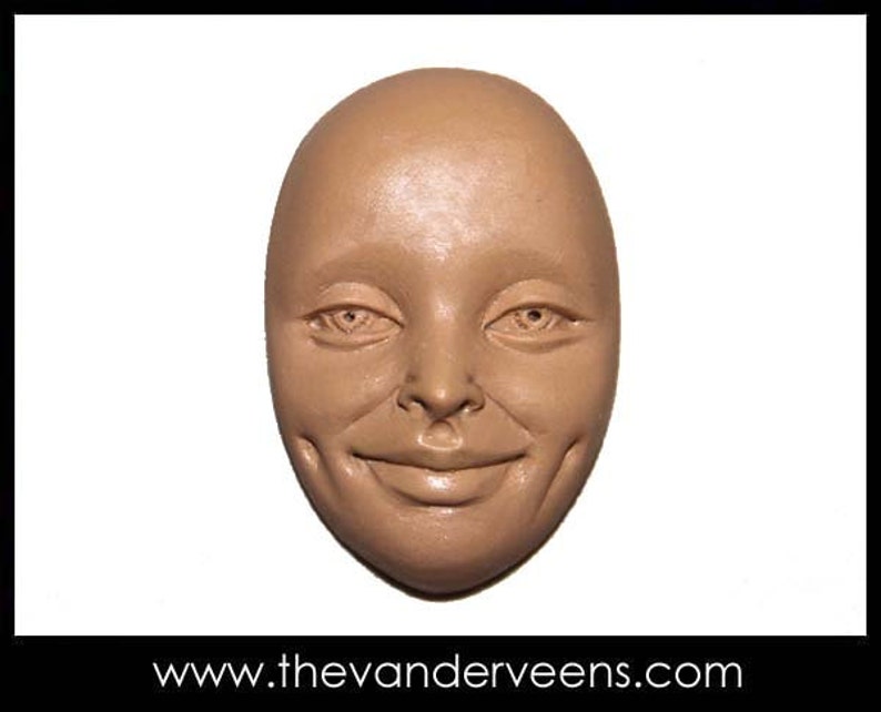 Puede incluir: Un primer plano de una escultura de arcilla marr&oacute;n de una cara con una expresi&oacute;n sonriente. La escultura tiene una superficie lisa y redondeada y presenta ojos, nariz y boca realistas.