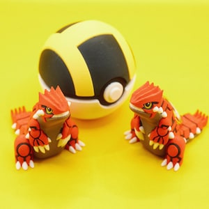 Könnte beinhalten: Zwei rote und schwarze Pokémon-Figuren, die einem Eidechsen ähneln, stehen auf einer gelben Oberfläche. Ein gelber und schwarzer Pokéball befindet sich im Hintergrund.