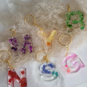 Porte-clés lettre initiale avec des fleurs séchées et paillettes