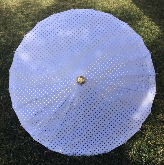 White parasol with gold polka dots