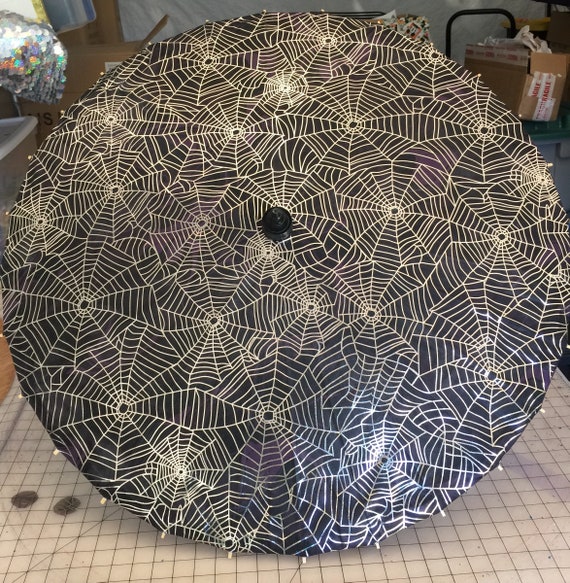 Silver spiderwebs on a black parasol