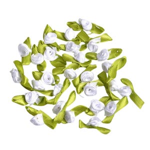 Peut inclure: Une collection de fleurs en ruban de satin blanc avec des tiges vertes. Les fleurs sont disposées en un tas lâche, certaines tiges se chevauchant.