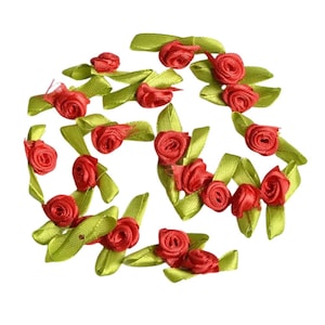 Peut inclure: Une collection de fleurs en ruban de satin rouge avec des feuilles vertes. Les fleurs sont disposées en cercle et sont parfaites pour ajouter une touche d'élégance à tout projet d'artisanat.