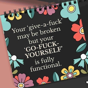 K&ouml;nnte beinhalten: Ein spiralgebundenes Notizbuch mit schwarzem Einband und einem bunten Blumenrand in Rosa, Gelb und T&uuml;rkis. Der wei&szlig;e Text lautet: Your 'give-a-fuck' may be broken but your 'GO-FUCK-YOURSELF' is fully functional.