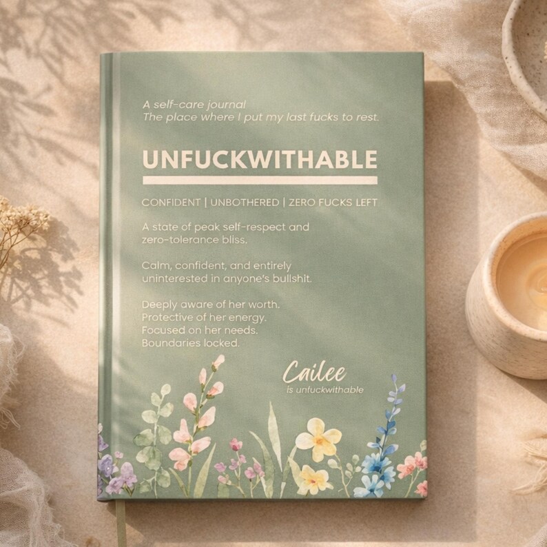 May include: A sage green self-care journal with the word "UNFUCKWITHABLE" in bold white letters. The cover features floral illustrations and text that reads "A self-care journal" and "CONFIDENT | UNBOTHERED | ZERO FUCKS LEFT". The journal is designed to promote self-respect and zero-tolerance.