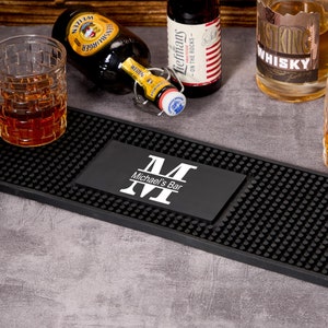 Può includere: Tappetino da bar nero con monogramma personalizzato e il testo "Michael's Bar". Il tappetino è realizzato in un materiale resistente e antiscivolo, ideale per proteggere il piano del tuo bar da schizzi e graffi.