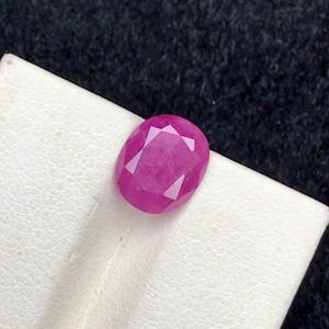 Könnte beinhalten: Ein lebhafter, ovaler Edelstein in Pink mit facettiertem Schliff.