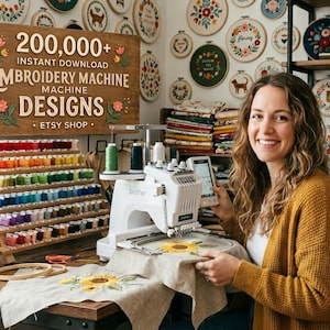May include: A woman smiles while working on an embroidery machine. The machine is set up on a wooden desk with a sunflower design. Behind her is a sign that reads "200,000+ INSTANT DOWNLOAD EMBROIDERY MACHINE DESIGNS ETSY SHOP."