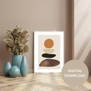 Op de afbeelding: Een digitale download van een afdrukbare kunstprint met een abstract ontwerp met gestapelde geometrische vormen in tinten bruin, zwart, beige en oranje. De print is op een lichtbeige achtergrond.