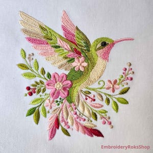Floral hummingbird machine embroidery design with pink flowers, green leaves, cream feathers and botanical branches.