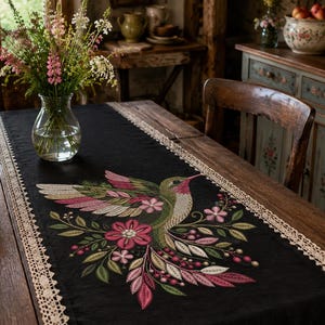 Floral hummingbird machine embroidery design with pink flowers, green leaves, cream feathers and botanical branches.