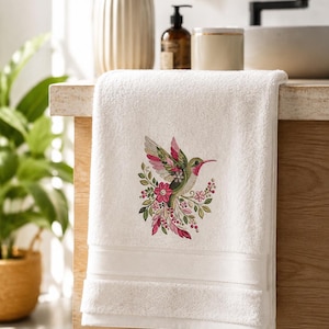 Floral hummingbird machine embroidery design with pink flowers, green leaves, cream feathers and botanical branches.