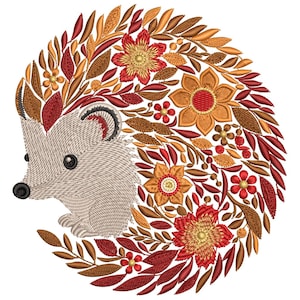Peut inclure: Motif brodé d'un hérisson avec un corps beige et un visage avec des yeux et un nez noirs. Le dos du hérisson est orné d'une couronne de feuilles et de fleurs d'automne dans des tons de rouge, d'orange et de marron.