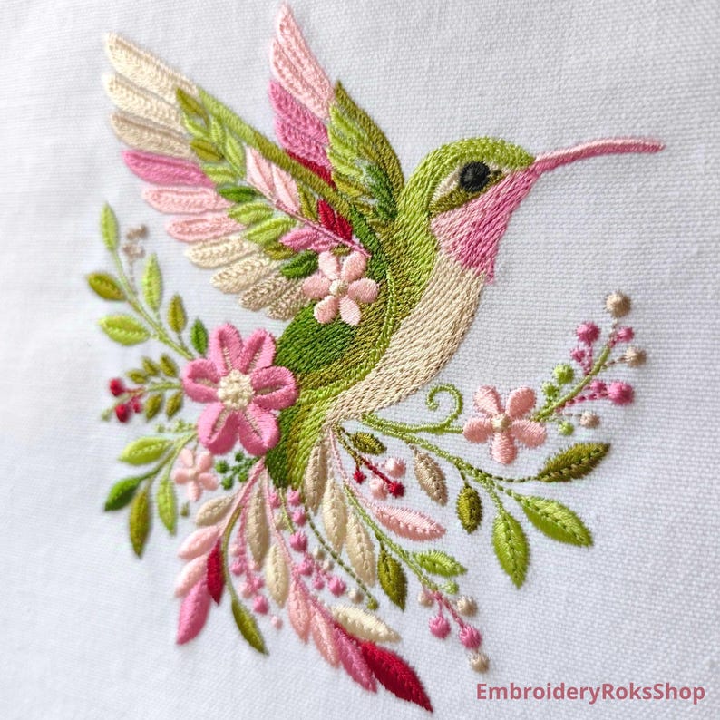 Floral hummingbird machine embroidery design with pink flowers, green leaves, cream feathers and botanical branches.