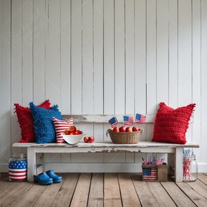 May include: A rustic white bench is adorned with patriotic decor. Red and blue pillows, a bowl of tomatoes, apples, and American flags create a festive scene. A jar and wooden box with American flag designs add to the theme.
