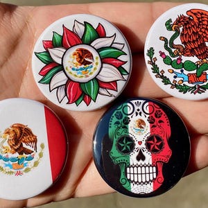 May include: Four round button pins with different designs featuring the Mexican flag. The first pin has a green, white, and red flag with the Mexican coat of arms in the center. The second pin has a green, white, and red flower with the Mexican coat of arms in the center. The third pin has a green, white, and red skull with the Mexican coat of arms in the center. The fourth pin has a green, white, and red eagle with the Mexican coat of arms in the center.