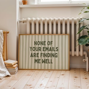 Op de afbeelding: Een rechthoekig bord met de tekst "NONE OF YOUR EMAILS ARE FINDING ME WELL" in donkergrijze letters. De achtergrond heeft verticale strepen in licht- en donkergrijs. De lijst is lichtbruin. Het bord staat tegen een muur.