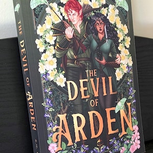 May include: A hardcover book titled "The Devil of Arden" from "The Arden Duology" series. The cover features two illustrated figures, floral accents, and the author's name, R.H. Linehan. The book is set against a dark background.
