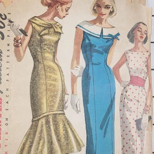 May include: Vintage Simplicity Printed Pattern featuring illustrations of three dresses. The dresses are in shades of yellow, blue, and white with various designs. The pattern details are printed on the cover, including the price of 50c.