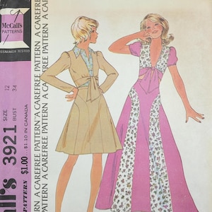 May include: Vintage McCall's 3921 sewing pattern featuring illustrations of a top and skirt. The pattern includes a tan dress with a collared shirt and a pink dress with floral accents. The pattern is for Misses' and Junior sizes.
