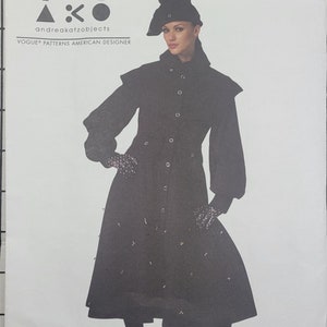 May include: A black coat with a high collar and a row of buttons down the front. The coat has a flared skirt and is decorated with small silver studs. The model is wearing a black hat and black gloves.