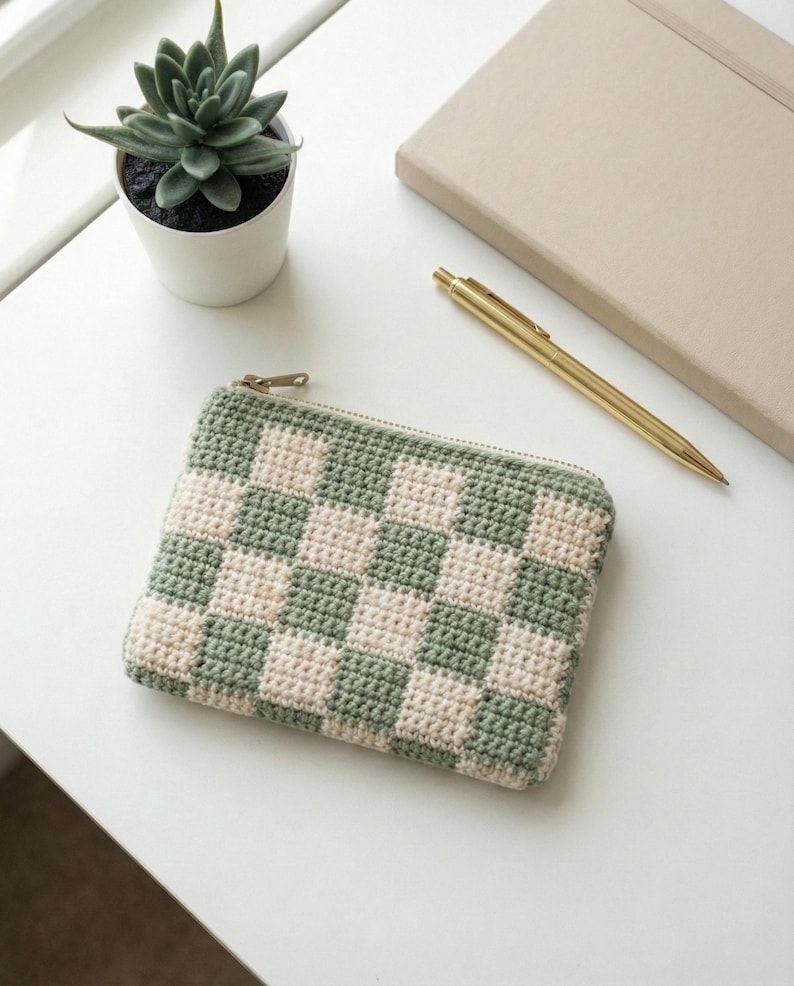 Crochet zipper pouch used as a pencil case on a desk, made from a PDF pattern