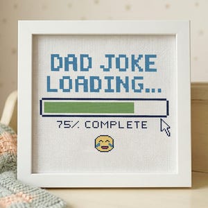 Pode incluir: Uma moldura quadrada branca contendo um padrão de ponto cruz em tecido branco. O design apresenta texto azul pixelizado lendo DAD JOKE LOADING..., uma barra de progresso verde, o texto 75% COMPLETE, um ícone de cursor e um emoji rindo.