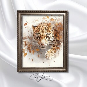 Puede incluir: Impresión en acuarela enmarcada de un jaguar con un pelaje manchado detallado, ojos color ámbar y una mirada enfocada. La obra presenta hojas de otoño en tonos marrones y dorados, sobre un fondo suave y neutro. El marco es de color oro apagado.