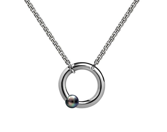 LUNA round tubular pendant hanging on a chain with tension set off centered black pearl in stainless steel by Taormina Jewelry