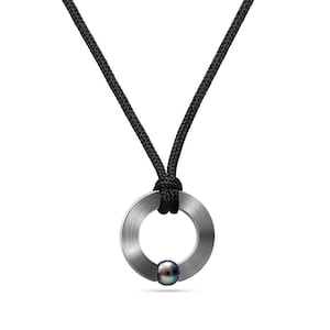 May include: A silver ring pendant with a black pearl, hanging from a black cord necklace.