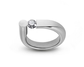 PORTANTE Flat and rounded tubular bypass ring with off centered tension set white sapphire in stainless steel