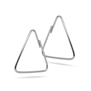Peut inclure: Une paire de boucles d'oreilles en argent de forme triangulaire. Les boucles d'oreilles sont simples et de design moderne.