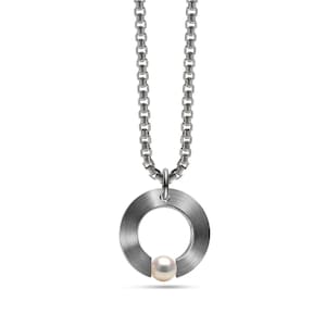 Peut inclure: Un collier en chaîne argent avec un pendentif circulaire contenant une petite perle au centre.