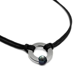 May include: A black cord necklace with a silver ring pendant featuring a black pearl in the centre.