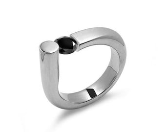 COLONNA Rounded style ring with a off centered tension set black diamond in stainless steel