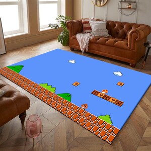 May include: A rectangular area rug featuring a pixelated design inspired by the classic Super Mario Bros. video game. The rug has a blue background with brick, question mark blocks, clouds, and green hills. The rug is a fun and nostalgic home decor item.