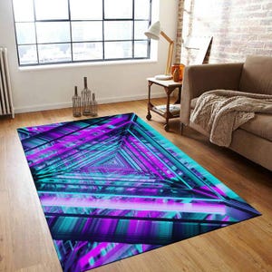 Könnte beinhalten: Ein geometrischer Teppich mit einem sich wiederholenden Muster aus Dreiecken in Blautönen und Lila. Der Teppich hat ein modernes, abstraktes Design.