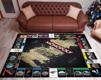 May include: A black and white Game of Thrones Monopoly board game rug with a map of Westeros in the center. The rug features the words "Game of Thrones" and "Monopoly" in red and white text. The rug is surrounded by a border of squares with different characters and locations from the show.