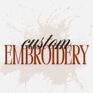 Könnte beinhalten: Grafikdesign mit den Worten "custom EMBROIDERY" in brauner Serifenschrift. Das Wort "custom" ist kursiv geschrieben. Der Hintergrund hat ein hellbeige Spritzmuster.