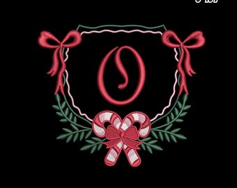 May include: Embroidered Christmas monogram frame with the letter "O" in red. The design includes red bows, candy canes, and green foliage on a black background. Text at the top reads "CHRISTMAS MONOGRAM FRAME 9 SIZES 3" TO 7".