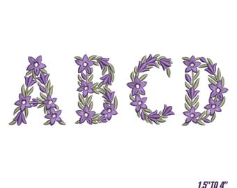 Può includere: Ricamo con font floreale con le lettere A, B, C e D, ognuna adornata con fiori viola e foglie verdi. Il design include sei dimensioni, da 3,8 a 10,2 cm. I file di progettazione sono disponibili in più formati.