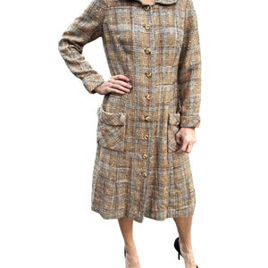 May include: A brown and blue plaid tweed dress with a button-up front and pockets. The dress has a collared neckline and long sleeves.