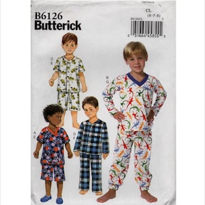 May include: Butterick sewing pattern B6126 for children's pajamas in size CL (6-7-8). The envelope features illustrations of four pajama sets: a short-sleeve set with a green pattern, a short-sleeve set with a sports ball print, a plaid set, and a long-sleeve set with a lizard print.