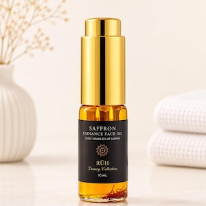 May include: A 10 mL glass bottle of Saffron Radiance Face Oil with a gold dropper cap. The black label features the text Saffron Radiance Face Oil, Huile Visage Éclat Safran, RÜH Luxury Collection, and 10 mL. Red saffron threads are visible inside.