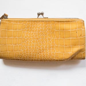 Cartera de mano vintage de los años 2000 con estampado de piel de cocodrilo sintética en color amarillo mostaza y bolsillo interior. Casual, minimalista, texturizada, colorida, vibrante, llamativa y primaveral.