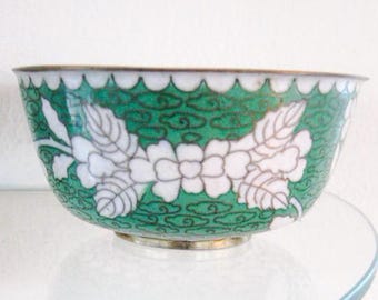 May include: A small, green and white bowl with a floral design. The bowl is made of porcelain and has a glossy finish.