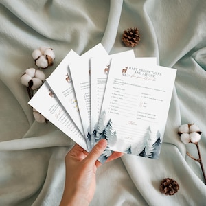 May include: A collection of white baby shower prediction and advice cards featuring a deer illustration and forest design. The cards have prompts for guests to complete, with the text "Baby Predictions and Advice for parents to be."